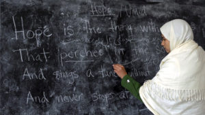 person writes poem on chalkboard